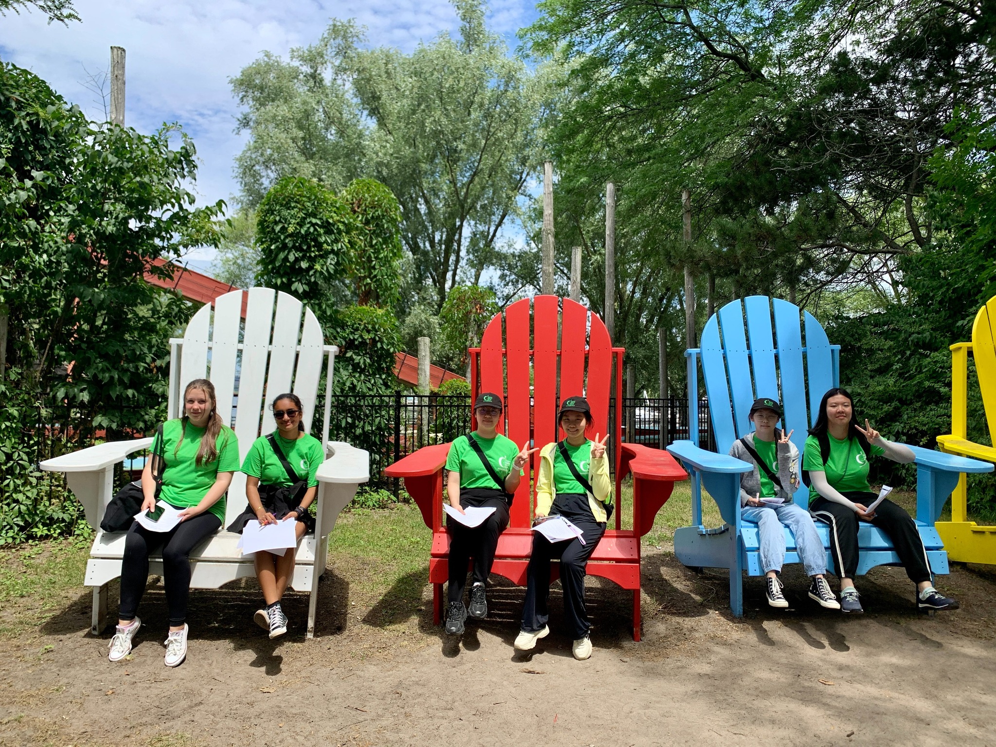 Students sitting on large Muskoka chairs at Toronto Island Open Gallery